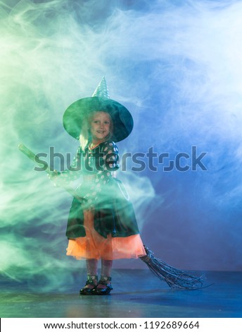 Baby girl in a witch costume for Halloween