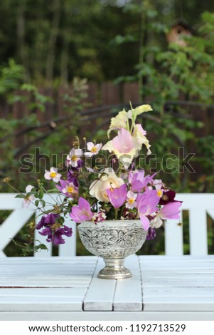 Autumn bouquet in vintage metal vase on garden background, outdoor and space, daylight, vertical photo