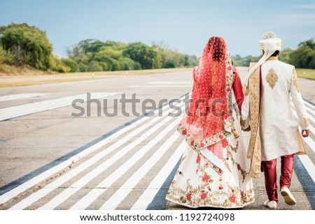 Pakistani  Indian bride and groom walking holding hands  Royalty-Free Stock Photo #1192724098