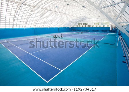 Background shot of modern indoor tennis court interior in blue colors, copy space Royalty-Free Stock Photo #1192734517