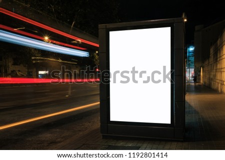 Light box display with white blank space for ads. Urban mock-up design concept with beautiful bus light trails at night. Long exposure
