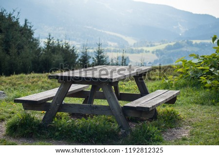  closeup of wooden picnic table in mountain landscape background 