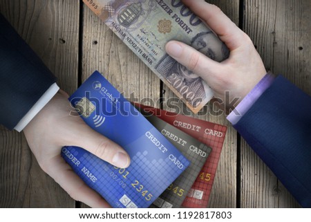 Two fiat currency bills being exchanged by two business people as part of a business transaction. 