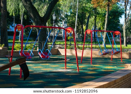 Rocking multi-colored swing in the playground in the park