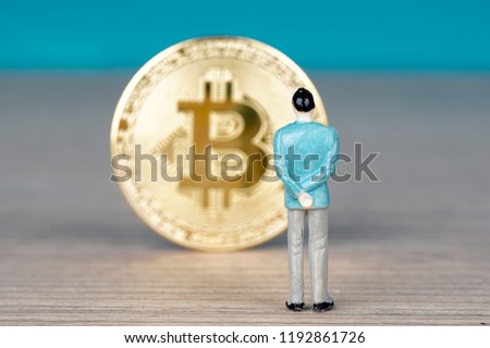 Bitcoin digital decentralised peer to peer on a wooden table and miniature figure side by side