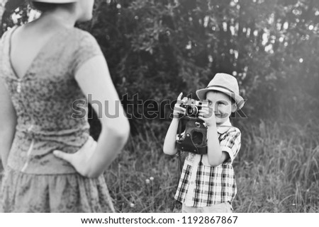 handsome little boy with retro camera and girl model