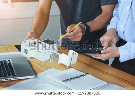 Architect showing new house model family to customer in office working on architects project