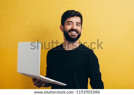 Young man with laptop on color background. Studio portrait. Royalty-Free Stock Photo #1192901086