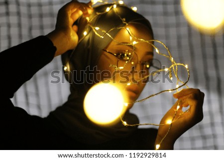Portraiture of Asian women wearing hijab with fairy light concept.