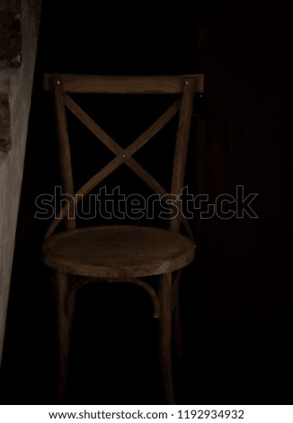 Wooden chair in the darkest corner of the room