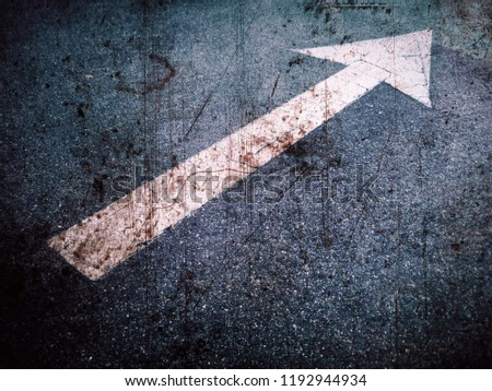           Close up grunge style arrow sign on road                     