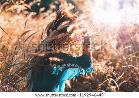 beautiful young woman on a field at sunset
