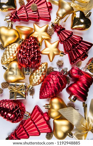 A top view of  mixed golden and red christmas ornaments on white