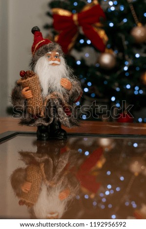 Santa Claus in front of illuminated Christmas tree with space to write message