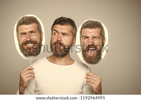 Hipster with winking and serious face hold portrait nameplate. Man with long beard and mustache. Guy or bearded man on grey background. Feeling and emotions. Barber fashion and beauty.