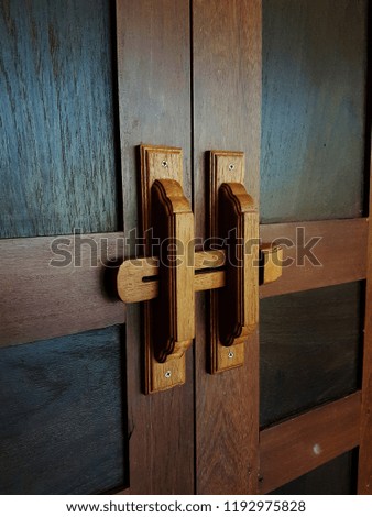 Contemporary door handle on a closed. solid wood interior door in room in thailand.