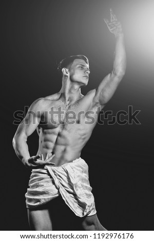 man muscular body in white fascia pose as bodybuilder isolated on black background