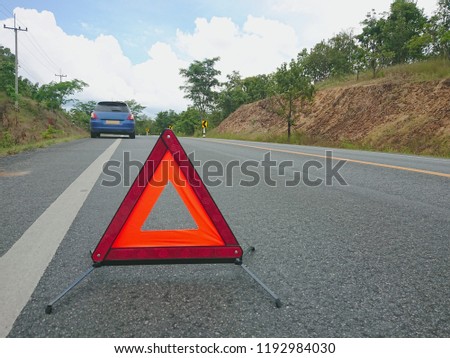 Red warning triangle on the road sign with a broken car