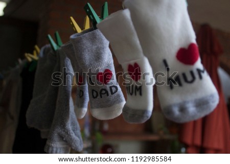 Newborn baby clothes and I love you Dad/ Mum socks drying in the rack (no trademark)