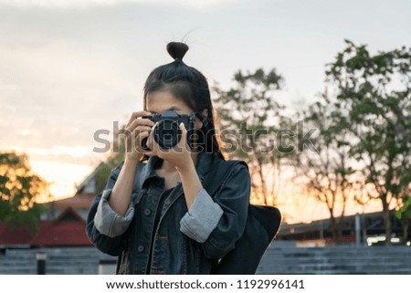 Beautiful Asian woman photographer taking a picture.