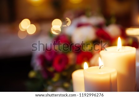 A blurred picture of candles burning on the dinner table