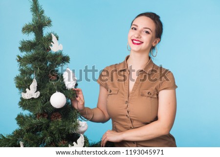 Christmas and holiday concept - Portrait of smiling girl with Christmas tree over blue background