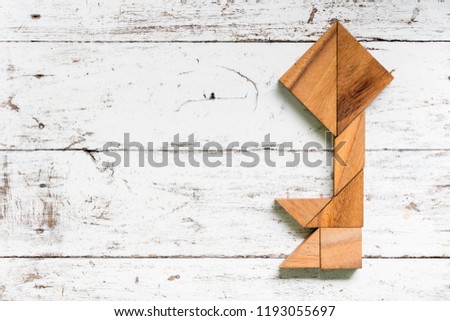 Tangram puzzle in key shape on old white wood background
