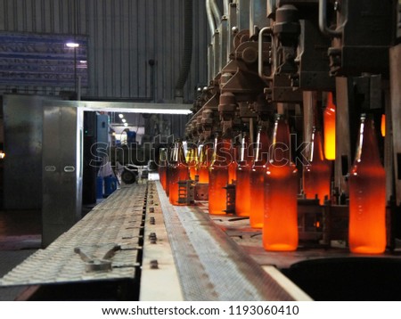 Manufacture of glass products, the machine produces hot bright bottles by means of metal molds for blowing and pressing hot glass