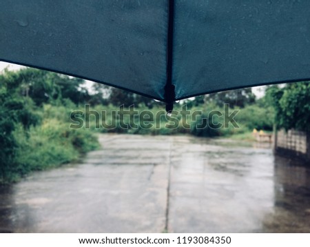 Rain drops falling from a black umbrella concept for bad weather, winter or protection