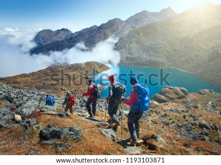 Group of tourists with backpacks descends down mountain trail to lake during hike in the national park Lantang, Nepal.
Beautiful inspirational landscape, trekking and activity. Royalty-Free Stock Photo #1193103871
