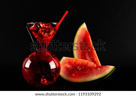 Red refreshing drink on the basis of watermelon on a black background, party night
