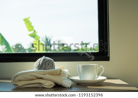 Cozy winter still life: mug of hot tea warm plaid on windows