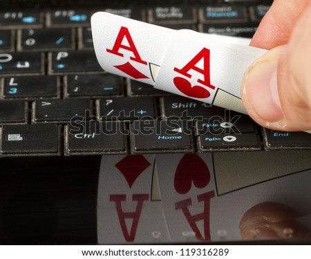 Two aces on a computer keyboard with a reflection.