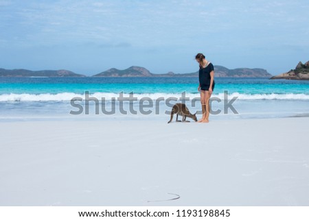 Young girl meeting a kangaroo on the beach in Lucky Bay, Australia