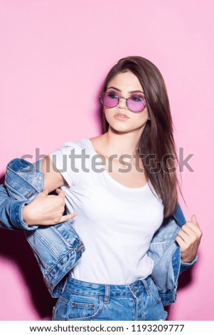 Pink glasses. Pink background. Stylish girl. Jeans jacket Fashion. Pretty Girl. Glamour concept. Fashion pretty smiling woman in a denim jacket.