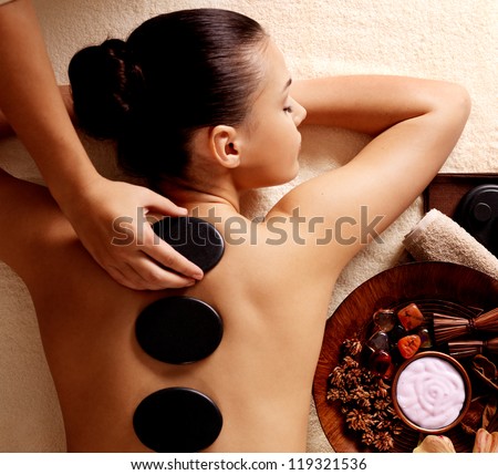Young woman getting hot stone massage in spa salon. Beauty treatment concept. Royalty-Free Stock Photo #119321536