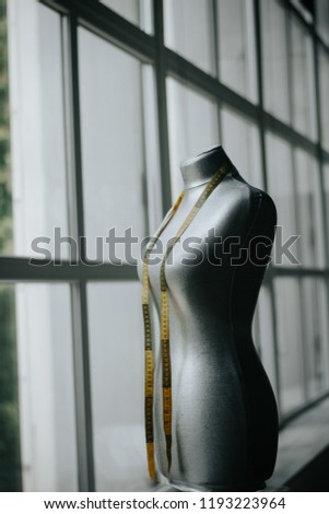 Grey dummy with measuring tape in tailors studio. sewing workshop. gray tailoring mannequin. professional dressmakers dummy with measuring tape