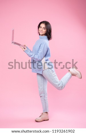 Businesswoman holding laptop. Love to computer concept. Attractive female half-length front portrait, trendy pink studio backgroud. Young emotional pretty woman. Human emotions, facial expression