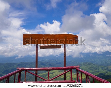 Blank of wooden signpost for advertisement with mountains and sky clouds background. Space for text