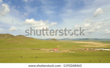 Beautiful green grass land, mountains and village houses 