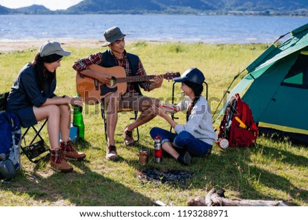 Happy group young friends in camping tent party having playing music fun together on outdoor holiday summer