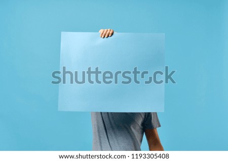blue sheet of paper and a man in the background                          