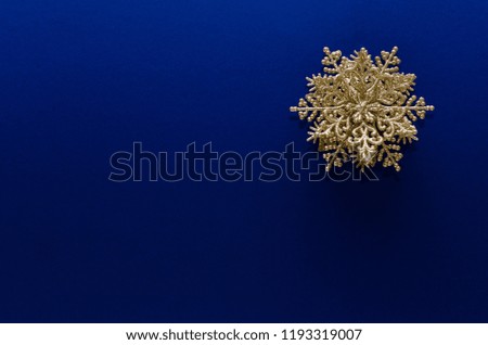 Decorative golden snowflake on the up-right corner of a blue background