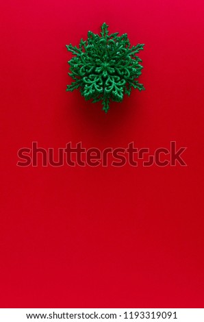 Green snowflake ornament on the red vertical gradient background
