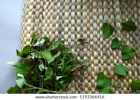 Fish mint (Houttuynia cordata) leaves isolated on rattan mat.