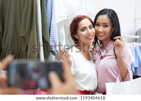 Young Vietnamese best friends posing together in fashion boutique
