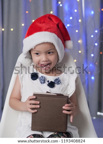 Happy Asian girl wearing Santa hat and open gift box, christmas concept.