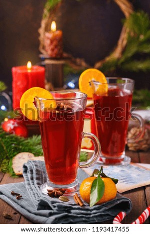 Merry Christmas with warm drink. Hot mulled wine or punch with fruits and spices on dark wooden background.