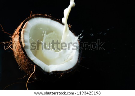 coconut and juice on black background