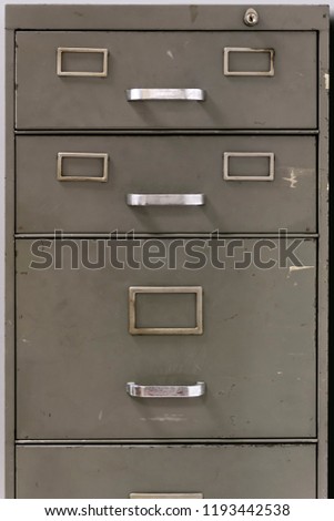 Front view of the drawers of metal filing cabinet of an old office